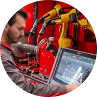 A man operates a Fronius robotic welding system